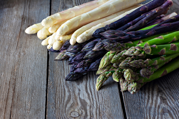 Photo of white, purple and green asparagus spears.