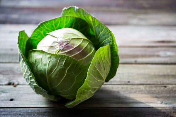 Photo of a head of cabbage on a table.