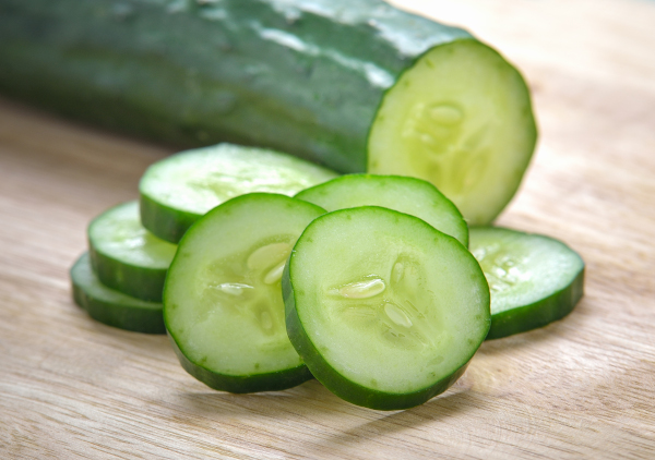 Cucumber with cut slices on a cutting board. 